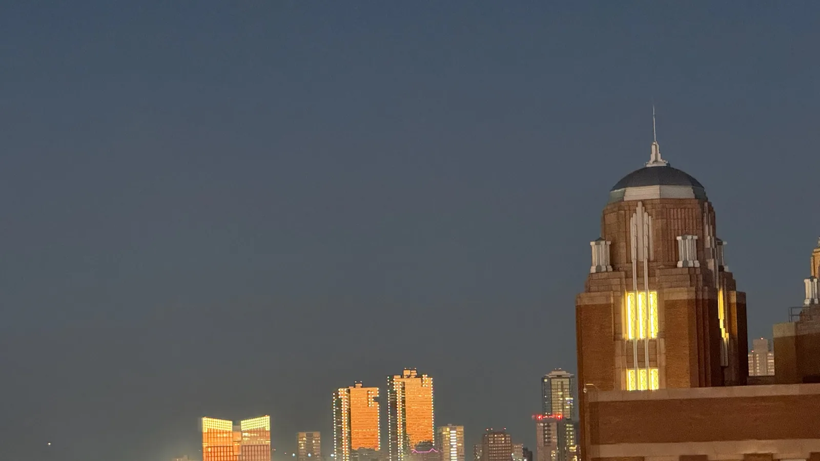Fort Worth skyline at dusk beside a historic tower
