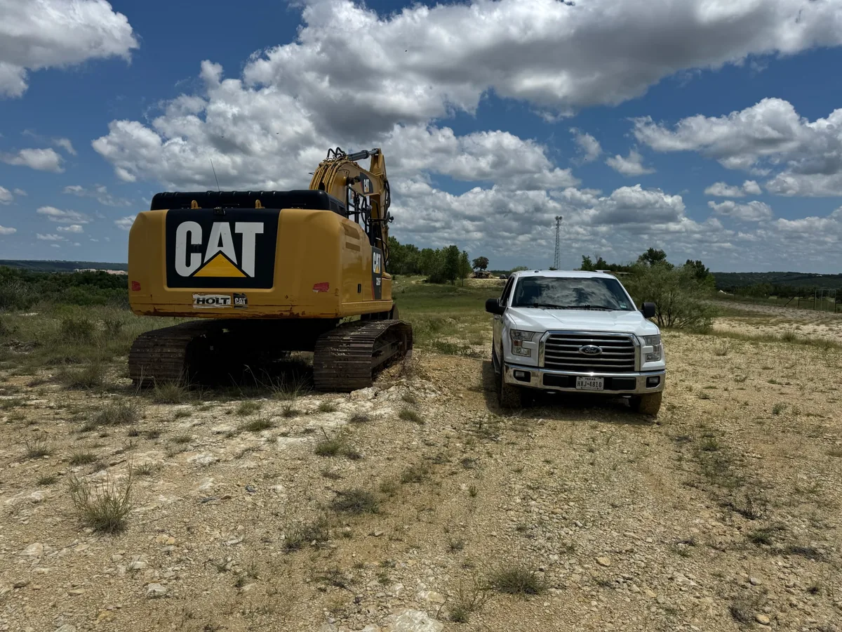 Excavator and pickup on cleared rocky ground, data center site work