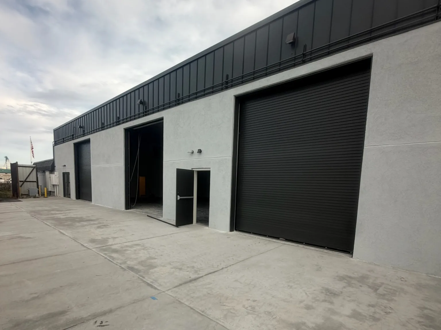 Rebuilt commercial building with new stucco walls and overhead doors, fire and water damage repair