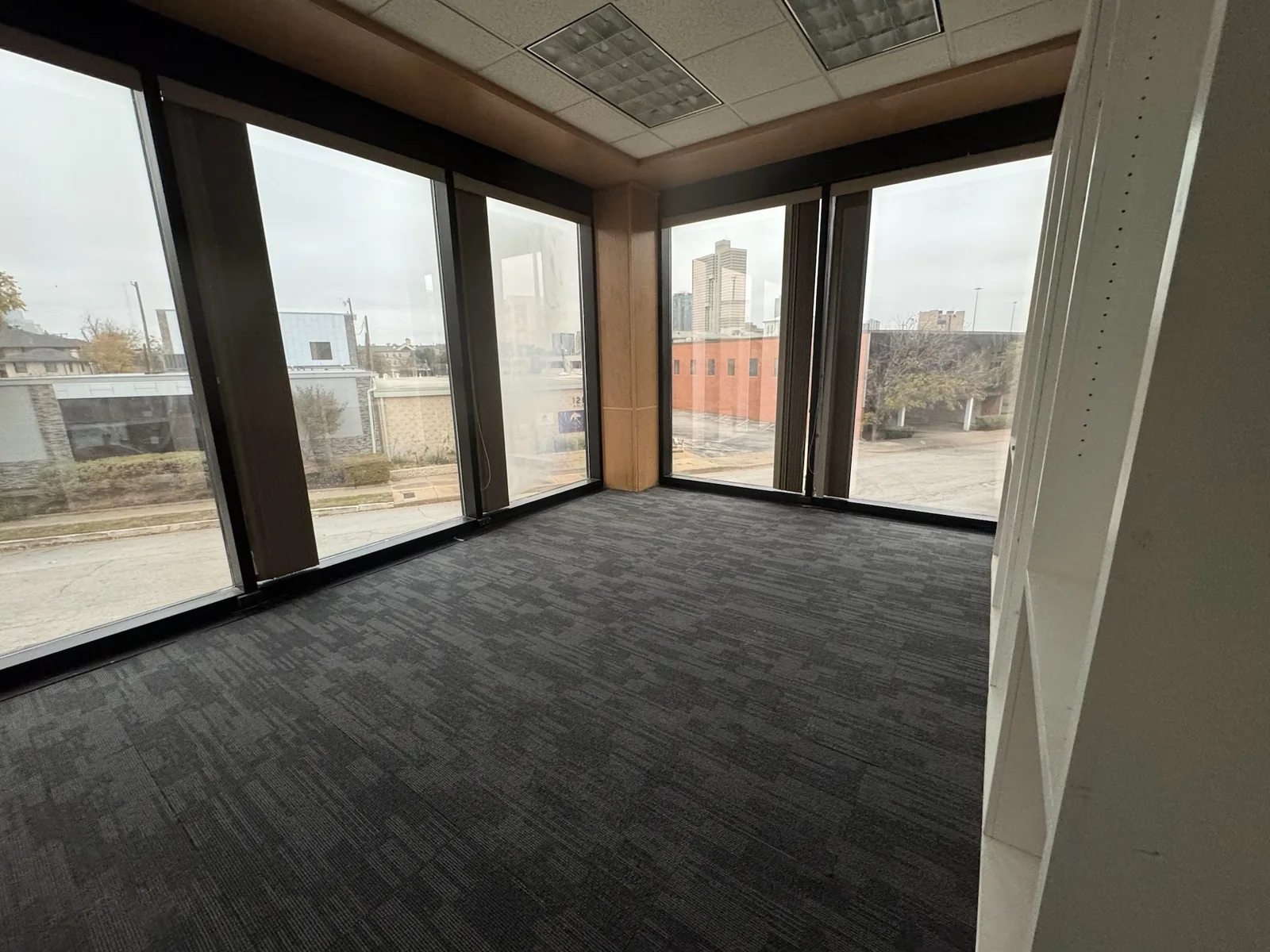 Finished office room with new carpet and tall windows facing downtown Fort Worth, commercial construction