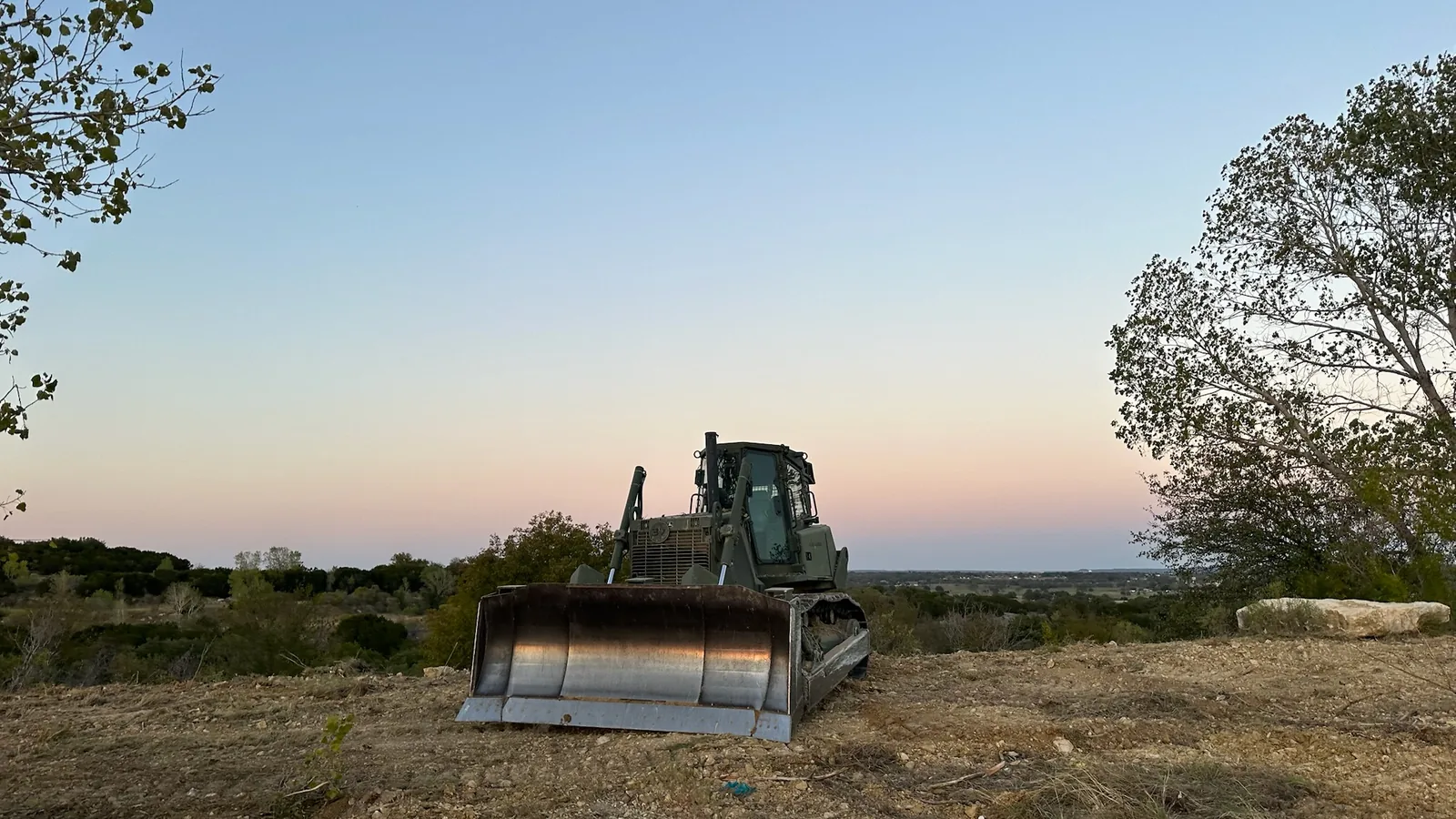 Dozer on freshly cleared ranch land at sunset, dirt work