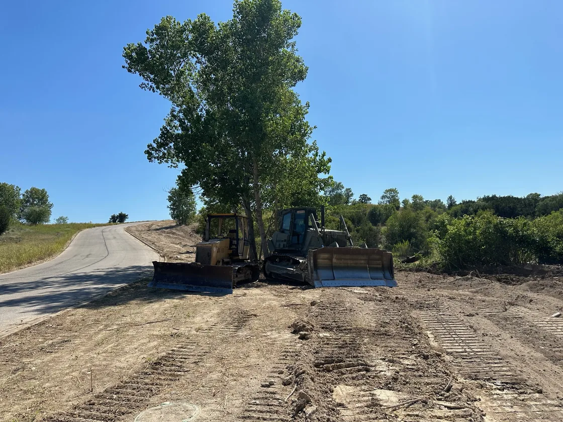 Two dozers on freshly graded ground along a road, land grading