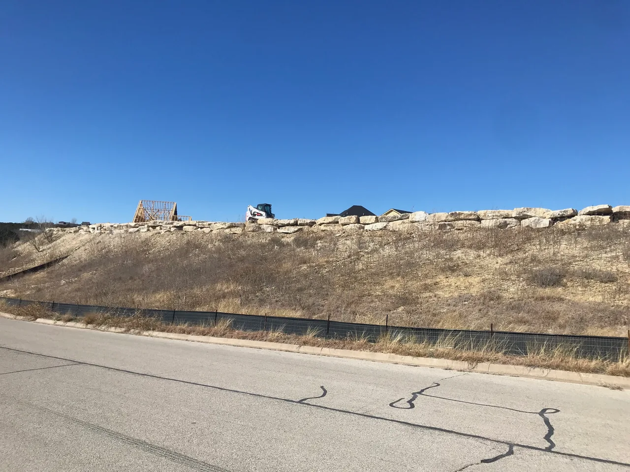Graded slope topped with limestone boulders above a road, land grading