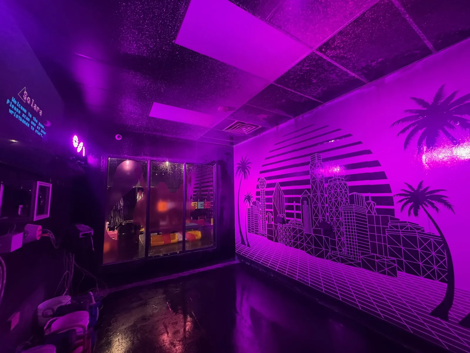 Purple lit game room with a projected welcome screen and digital displays, low voltage and AV wiring