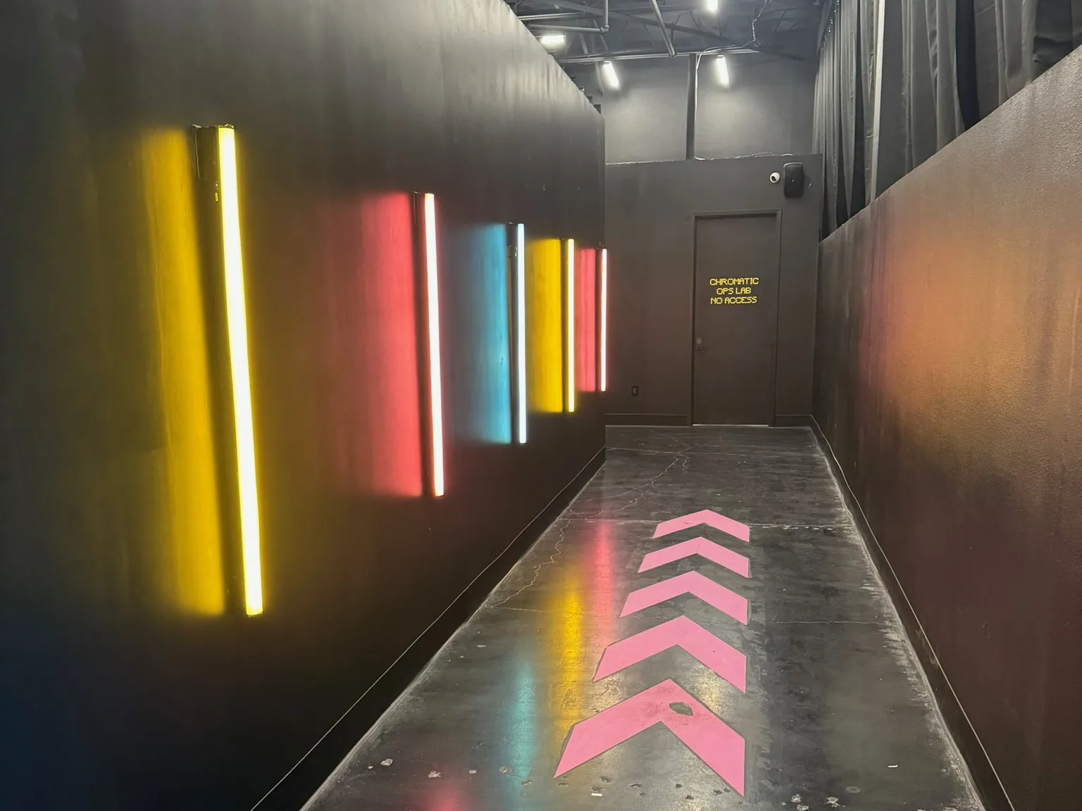 Dark corridor lit by colored LED light bars along the wall, low voltage and AV wiring