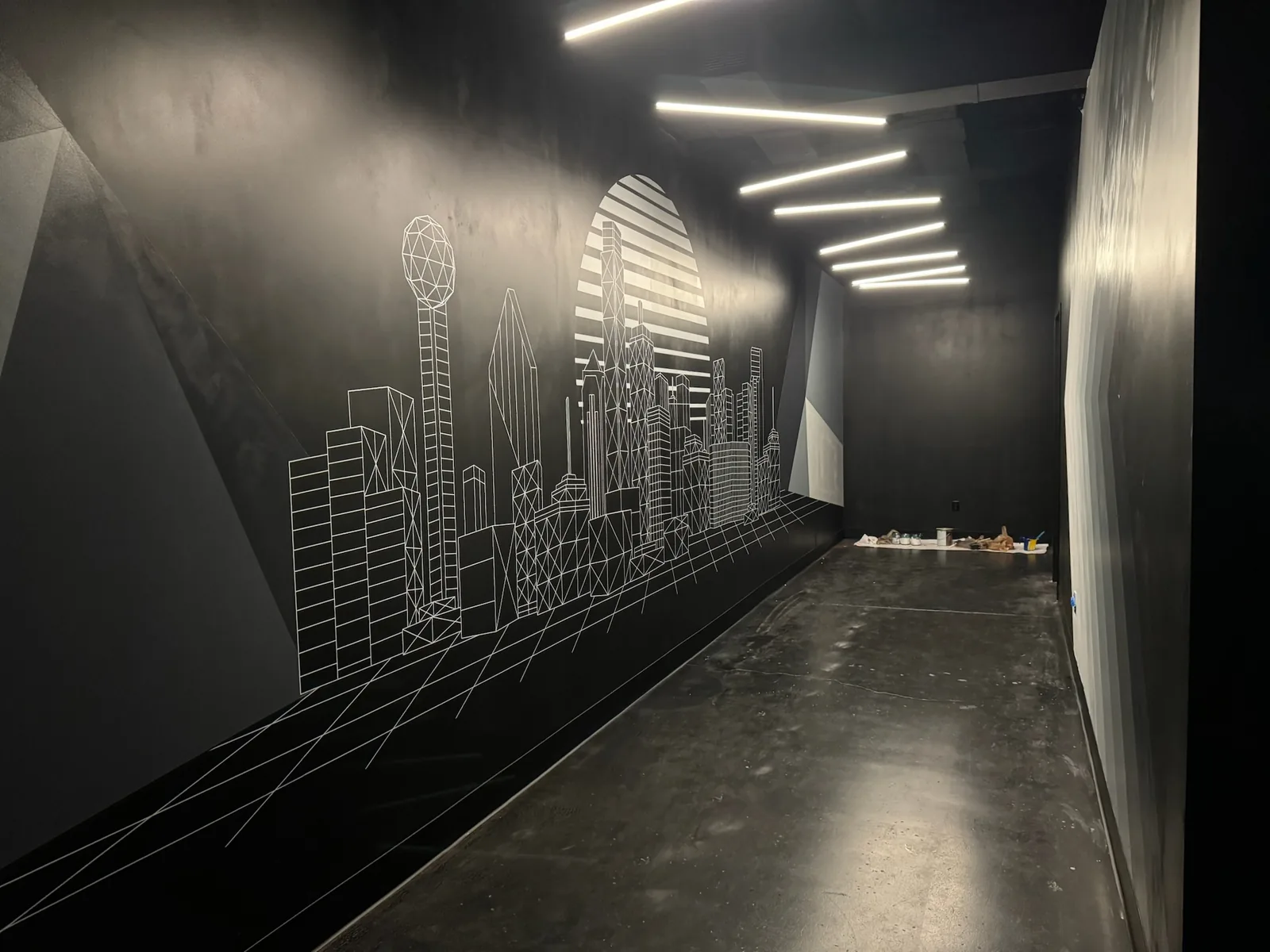 Black corridor with linear LED light runs and a skyline mural, low voltage and AV wiring