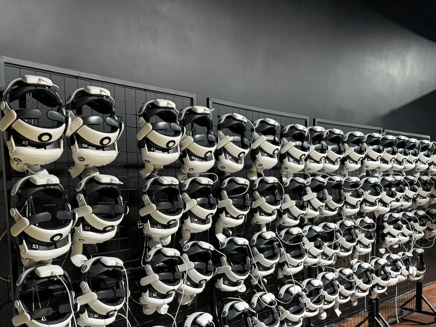 Rows of VR headsets on charging racks in a finished venue, low voltage and AV wiring