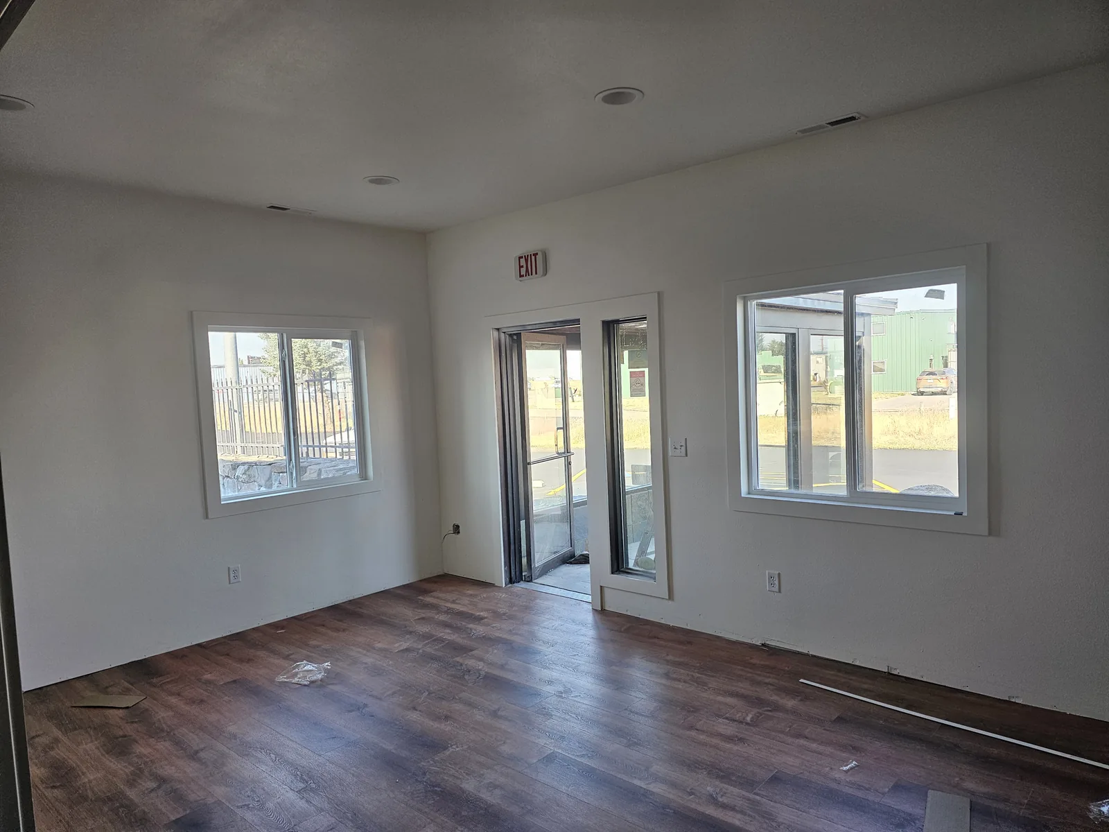 Finished room with new plank floors, windows and a glass door, commercial construction