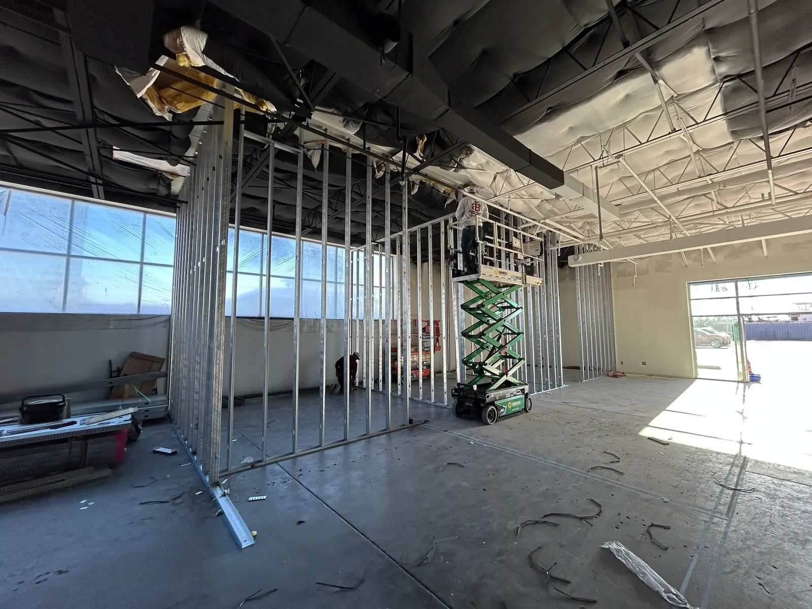 New metal stud walls and a scissor lift inside the venue shell, commercial construction