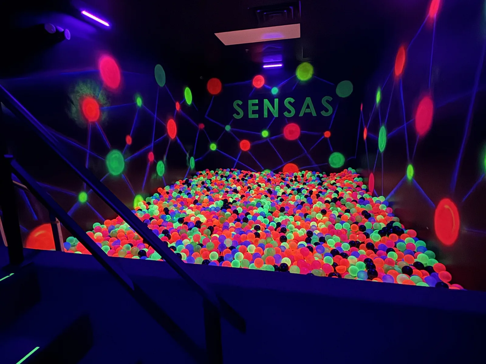 Glow in the dark ball pit under UV lighting with SENSAS on the wall, commercial construction