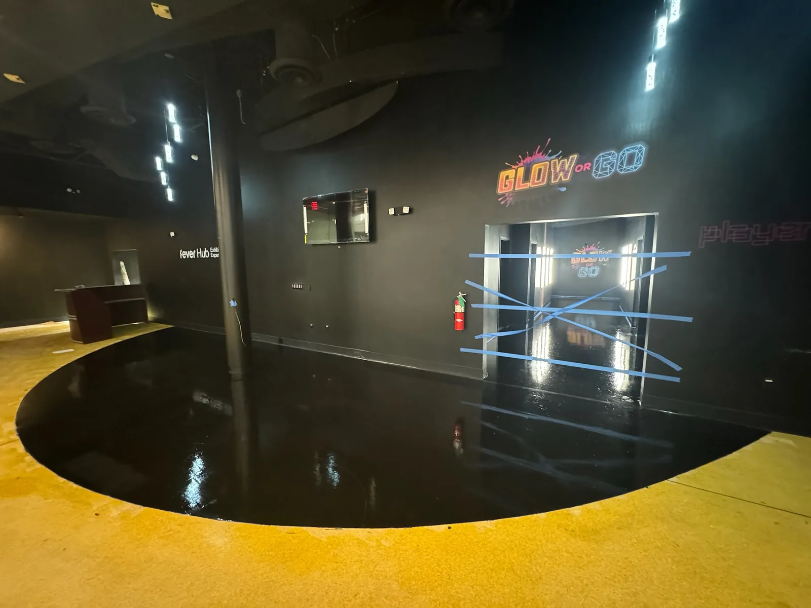 Venue lobby with a new black epoxy floor and the Glow or Go sign, commercial construction