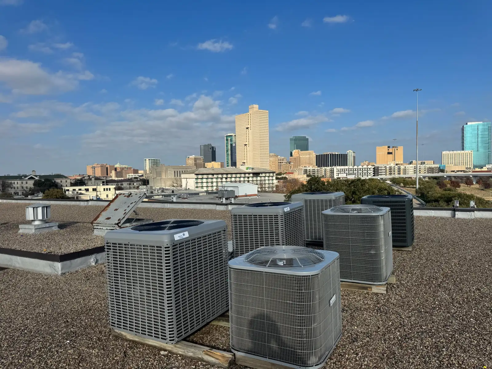 New rooftop air conditioning units with the downtown Fort Worth skyline behind, commercial construction