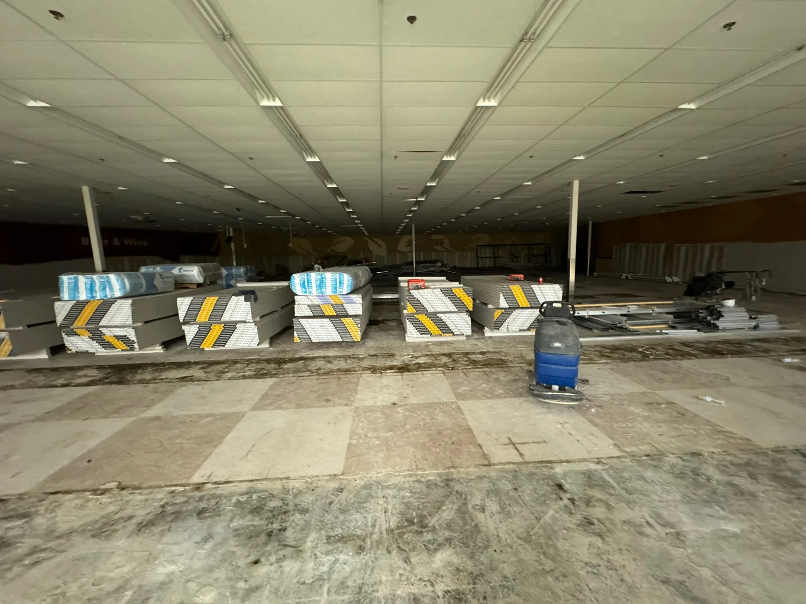 Gutted big box store with drywall and insulation staged on the floor, commercial construction