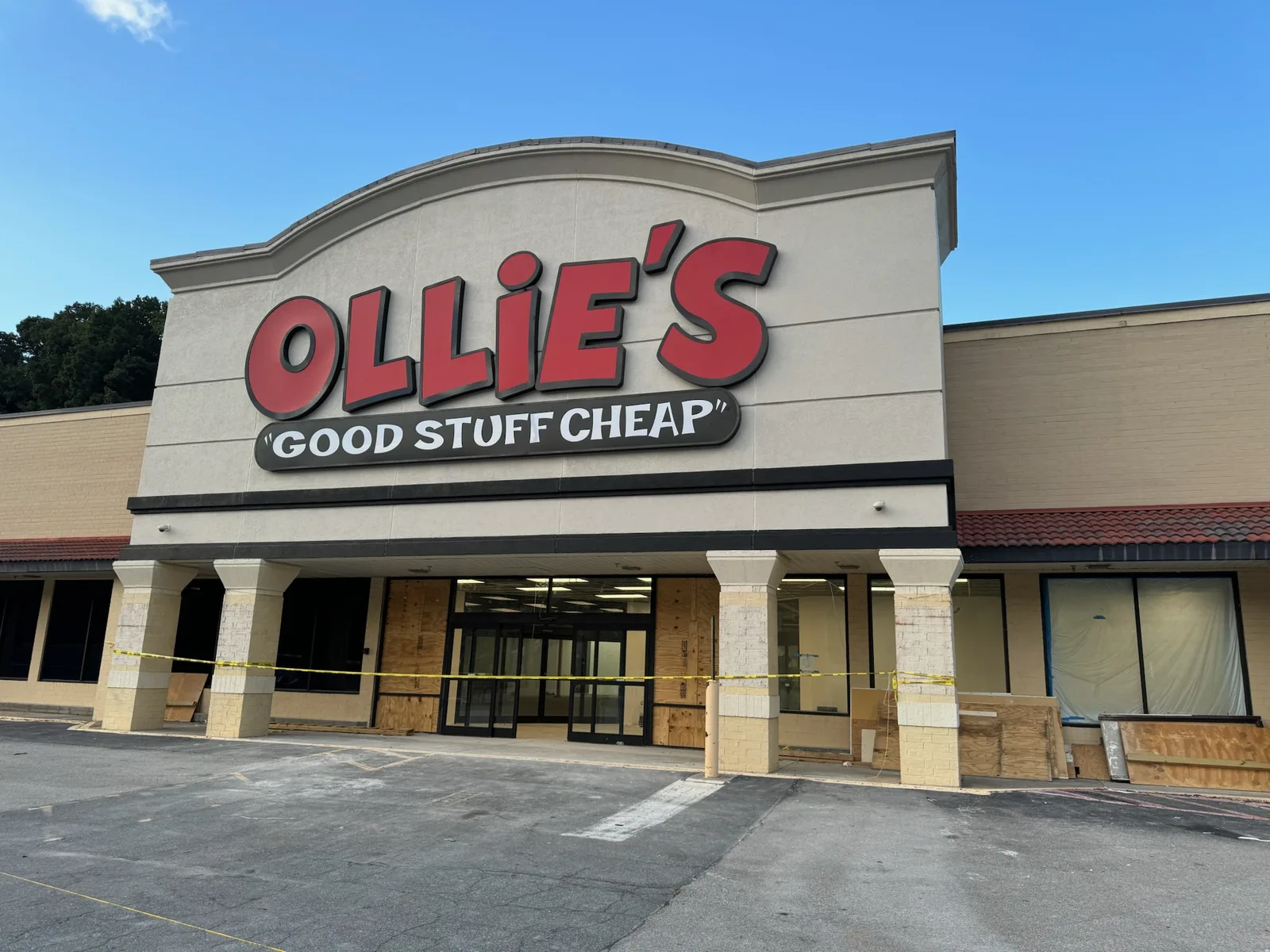 New Ollie's sign over a storefront with plywood and caution tape, commercial construction