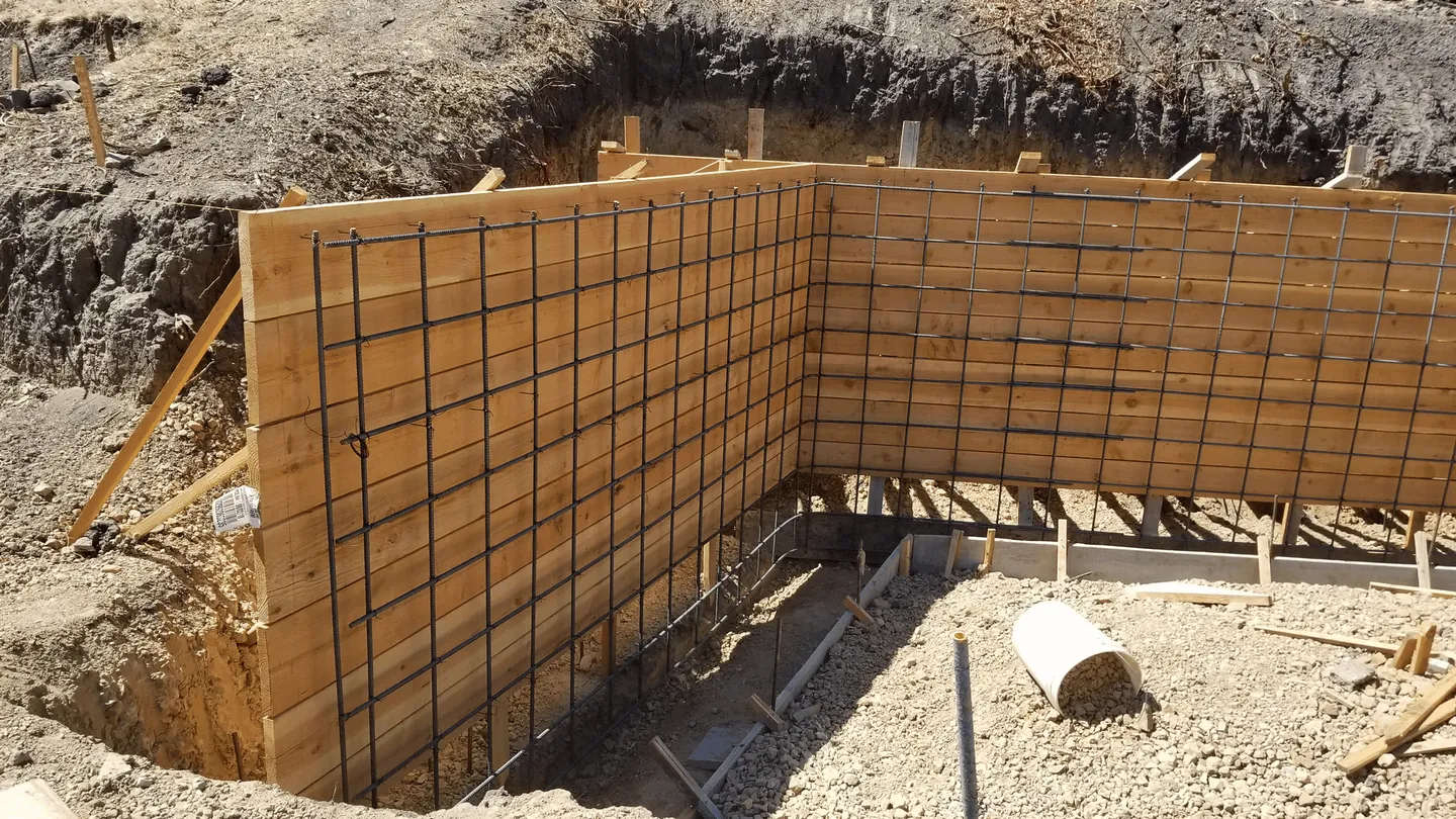 Forms and rebar set for a poured concrete retaining wall in an excavation