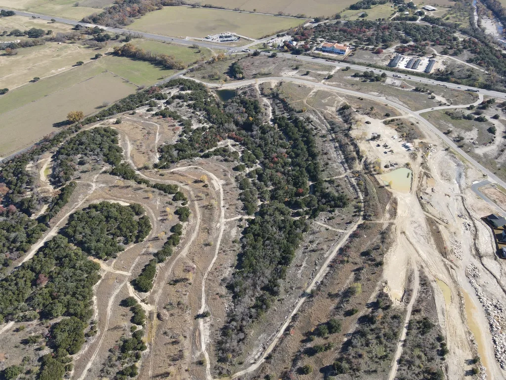 Aerial view of new roads cut through cedar and cleared land, road building