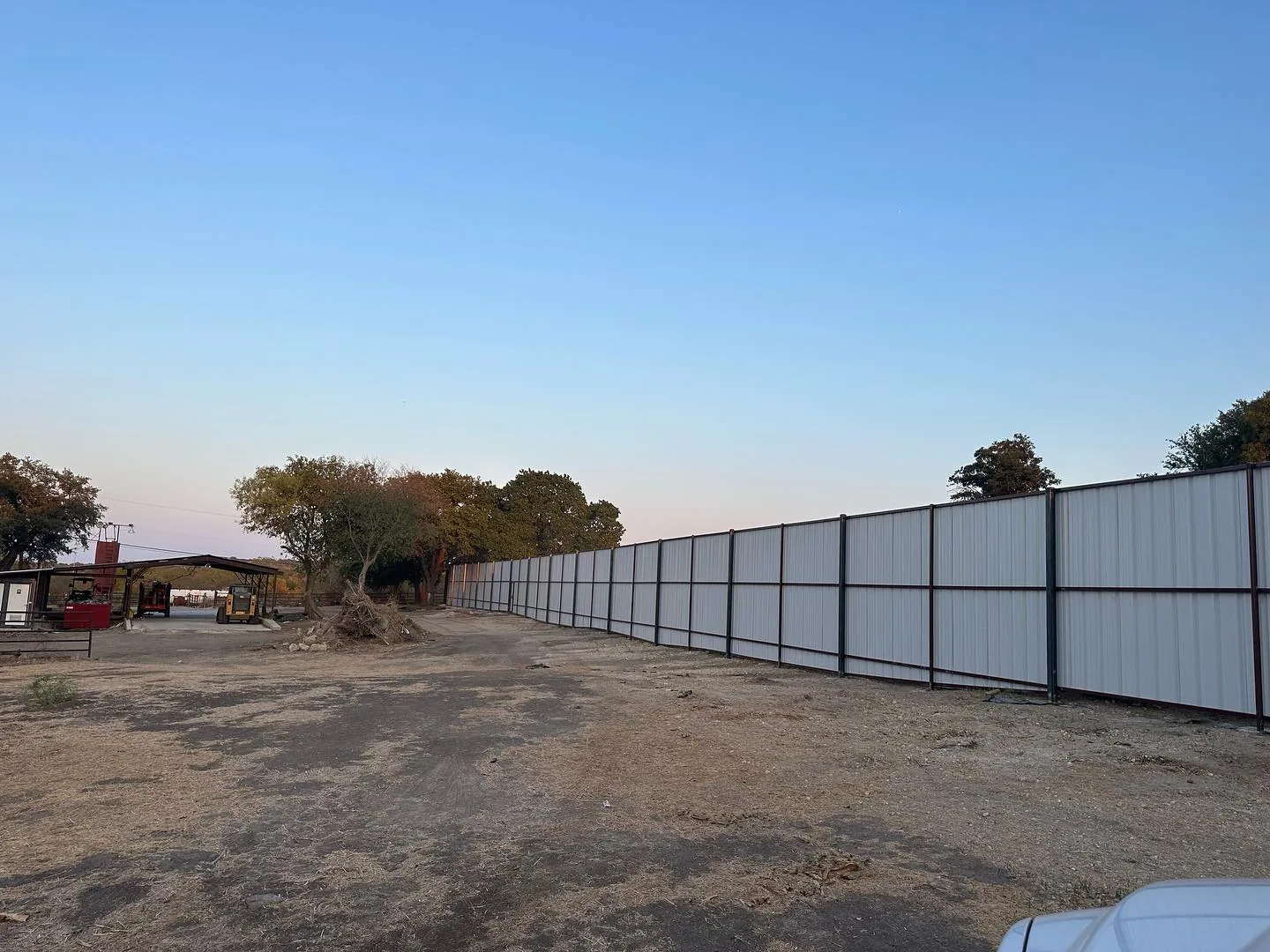 Graded ranch drive along a new steel fence line, road building