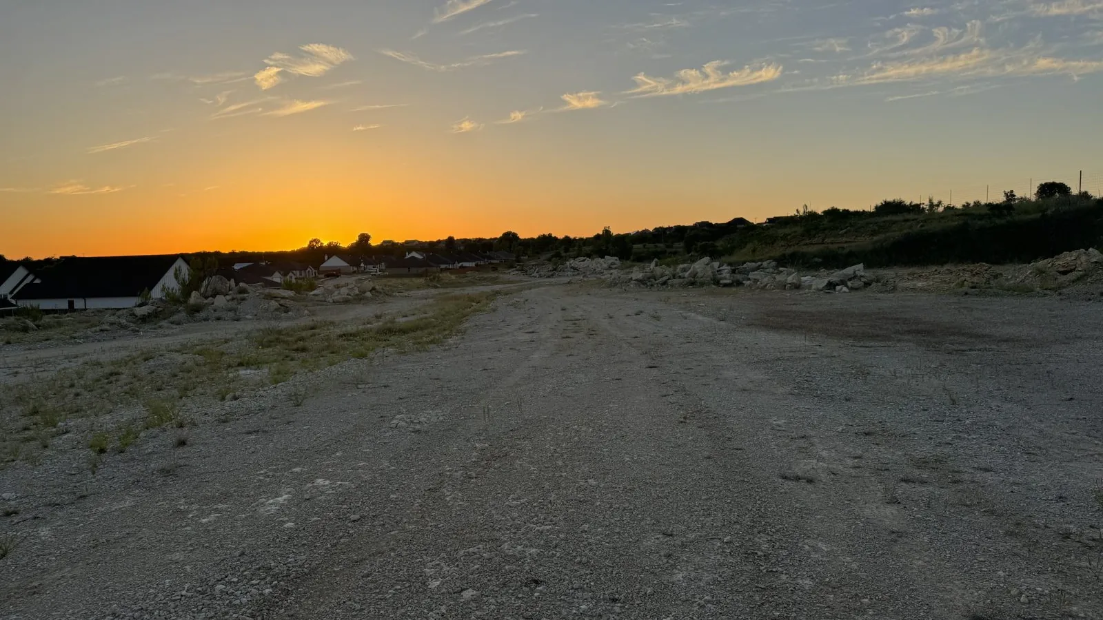 Graded lot at sunset with new homes on the horizon