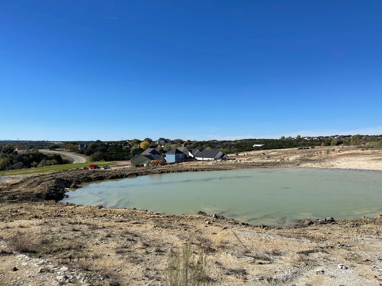 New pond dug into rock and filling with water, site drainage