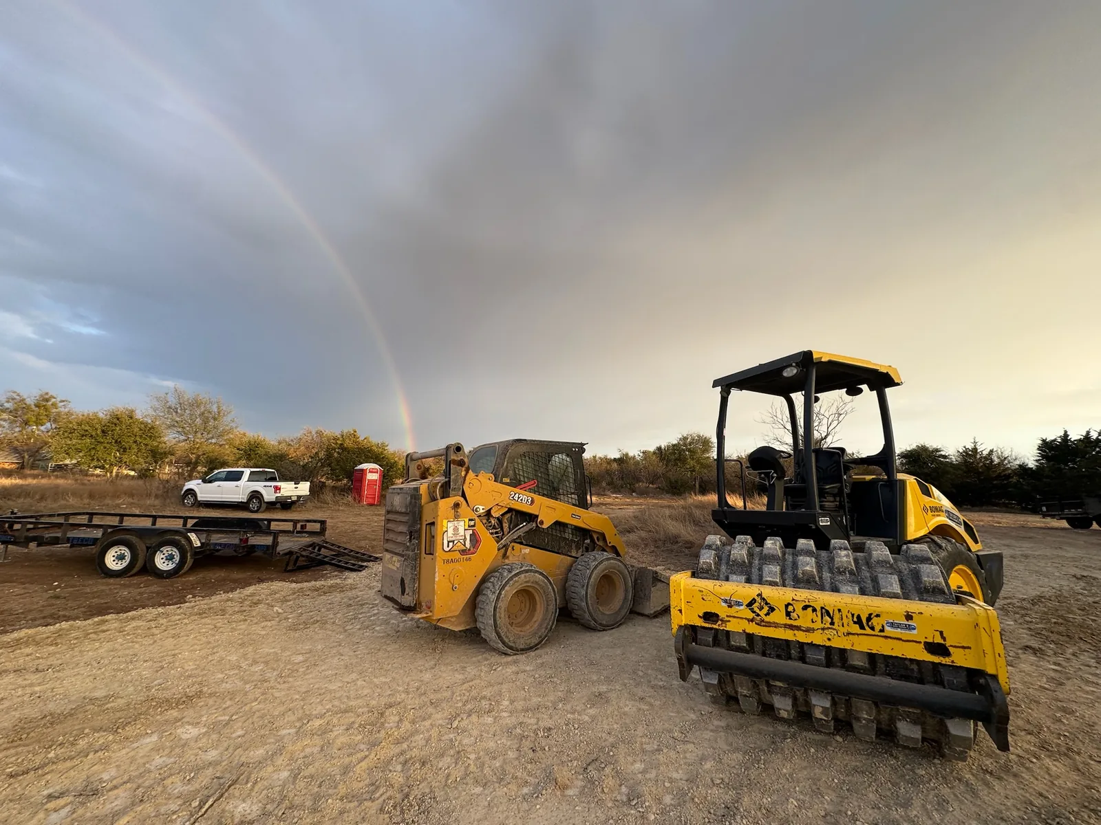 Padfoot roller and skid steer on a graded building pad, site preparation