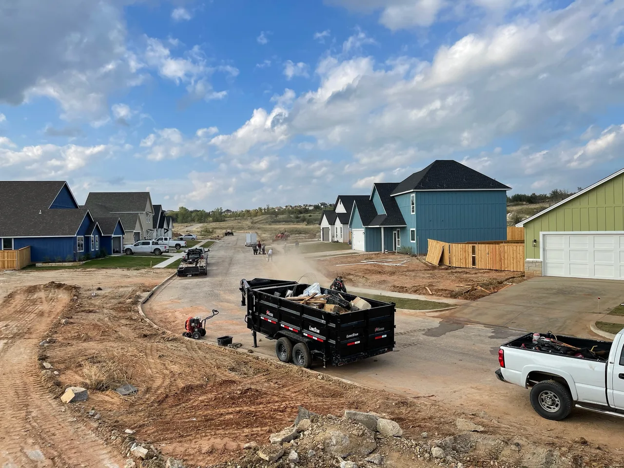 Graded lots and a dump trailer on a new subdivision street, site preparation