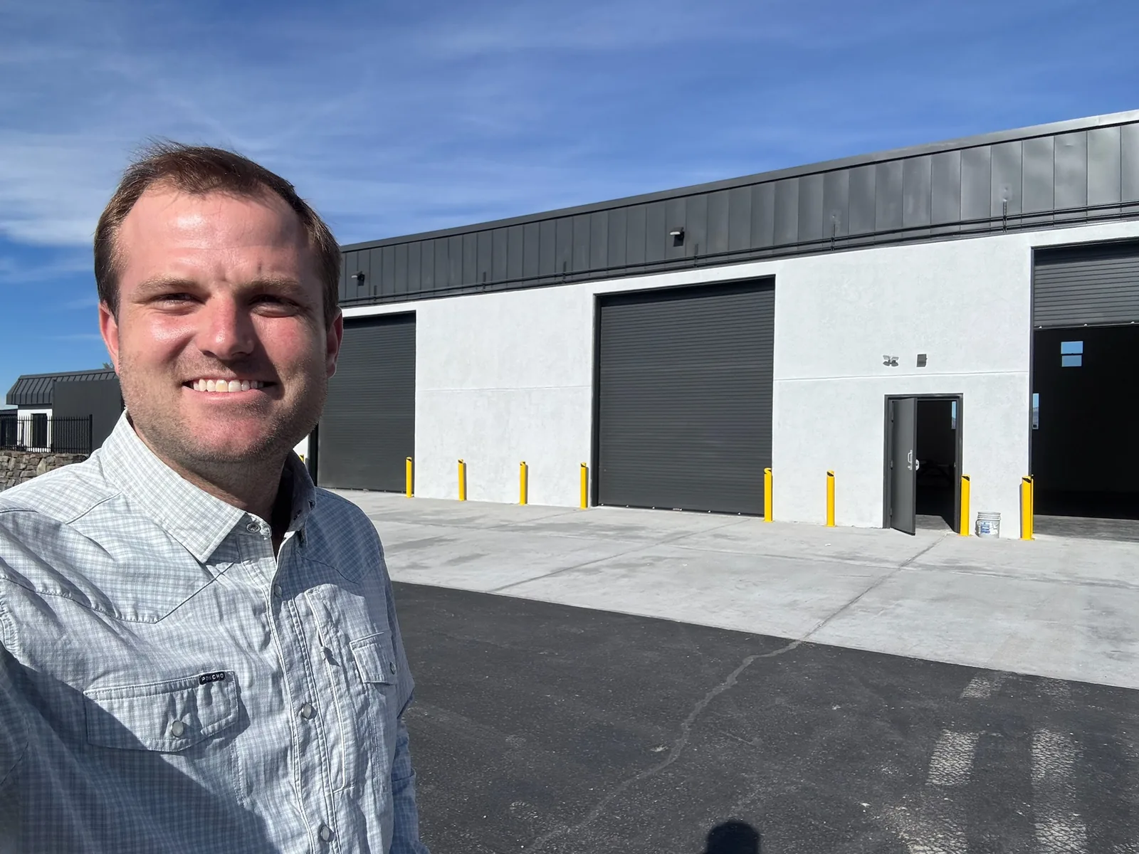 Smiling selfie in front of a new commercial building on a job site